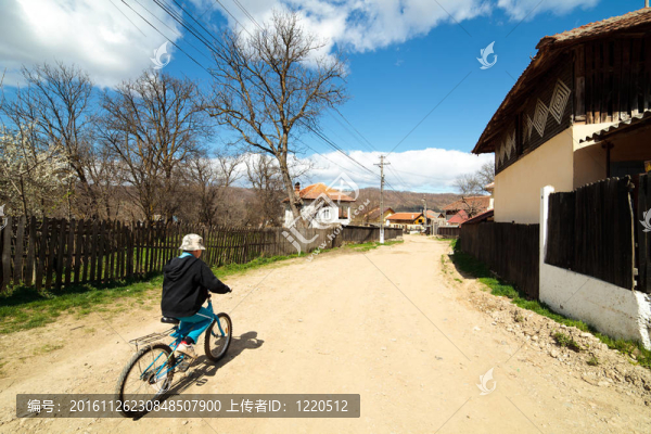 在農(nóng)村公路上騎自行車的男孩