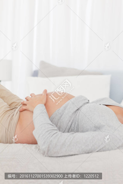 一個未來的母親躺在床上，在家里摸她的肚子