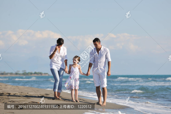 快樂的年輕家庭在海灘上玩得很開心