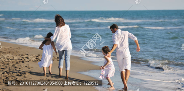 快樂的年輕家庭在海灘上玩得很開心