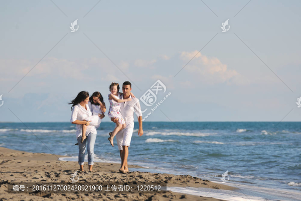 快樂的年輕家庭在海灘上玩得很開心