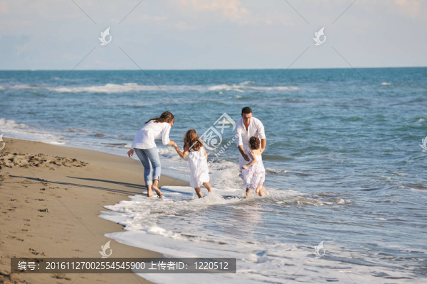 快樂的年輕家庭在海灘上玩得很開心