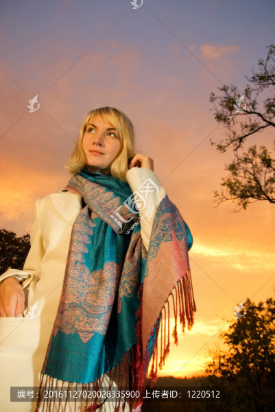 夕陽天空背景上的金發(fā)女孩