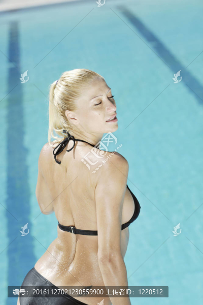 美麗的女人在游泳池放松