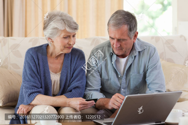 退休夫婦在看他們的筆記本電腦