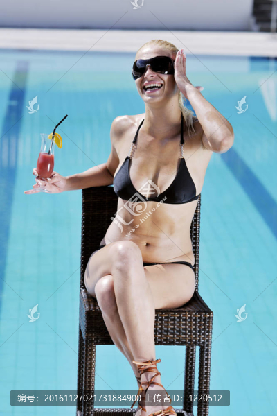 美麗的女人在游泳池放松