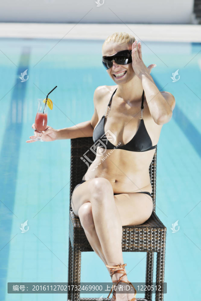美麗的女人在游泳池放松
