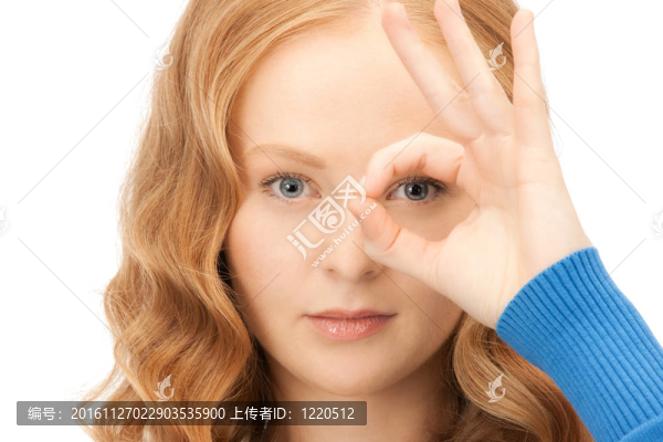 可愛的女人透過手指看洞