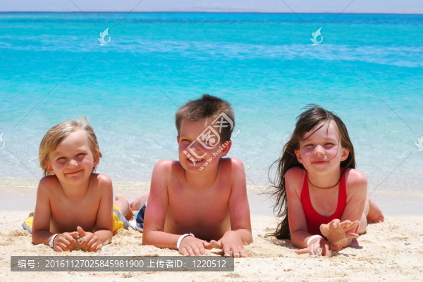 三個(gè)孩子躺在Beach