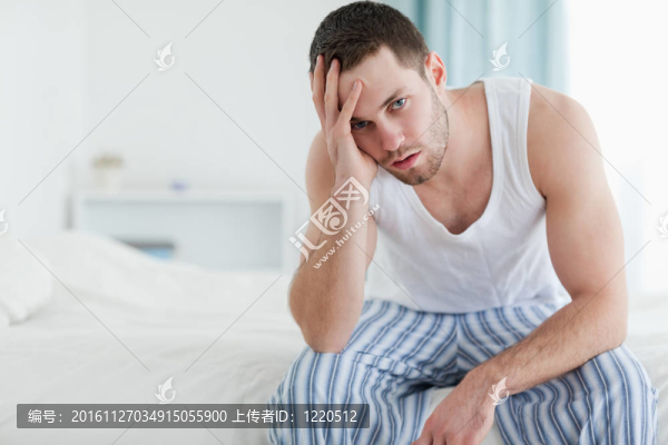 沮喪的人坐在他的床上