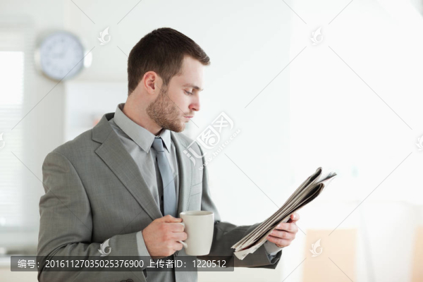商人一邊喝茶一邊看新聞