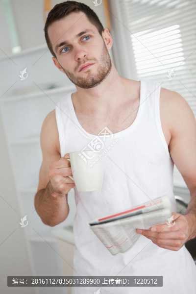 一個健康男子喝茶的肖像，一邊讀新聞
