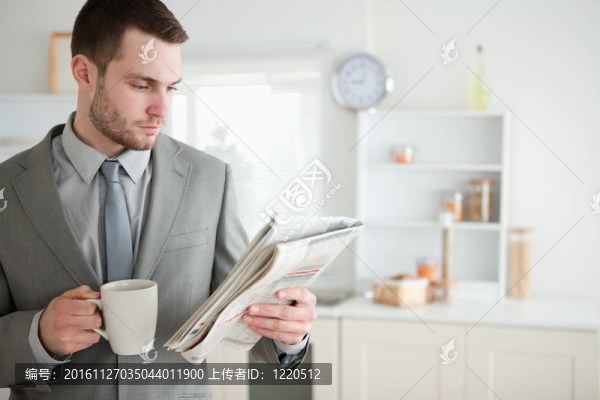 商人一邊喝咖啡一邊看新聞