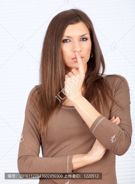 美麗的年輕女子站在思考與手指的嘴