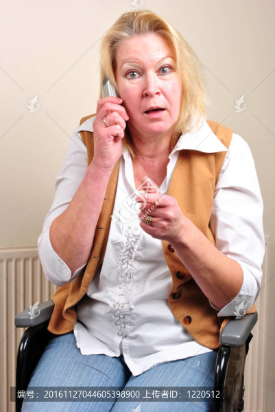 坐輪椅的婦女正在打電話