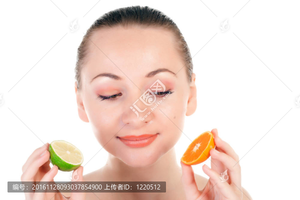 幸福的模特兒擺出一片多汁的橘子和一半的酸橙