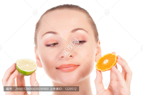 幸福的模特兒擺出一片多汁的橘子和一半的酸橙