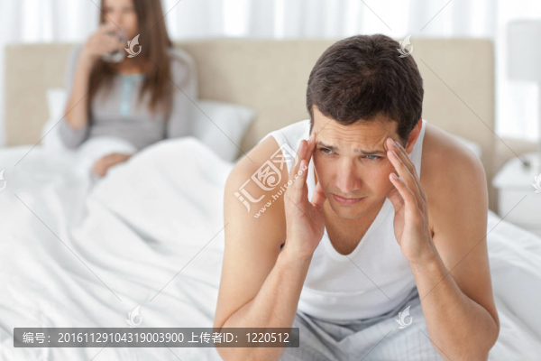 男人頭痛與女友坐在床上