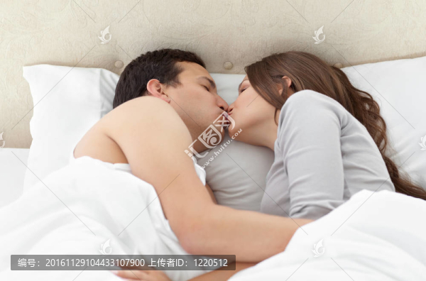 可愛的情侶在床上互相親吻
