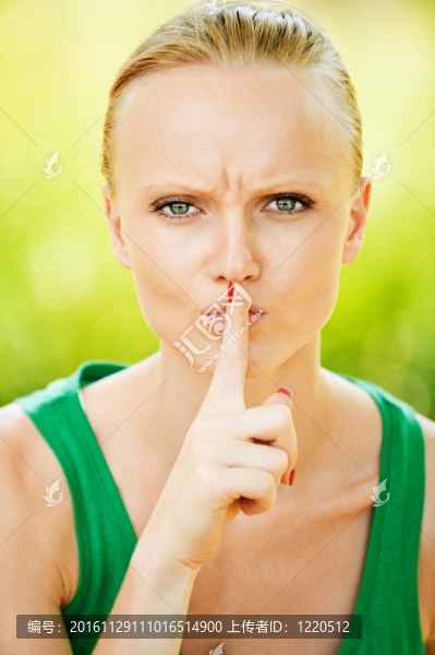 美麗的女人手指靠近她的嘴
