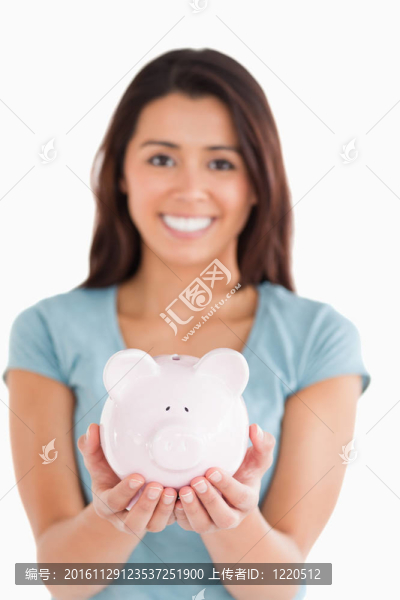華麗的女人擺著一個儲蓄罐