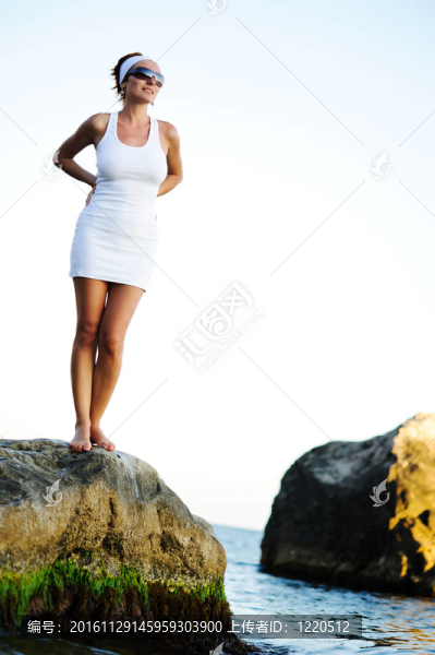 站在海邊的一塊石頭上的女人