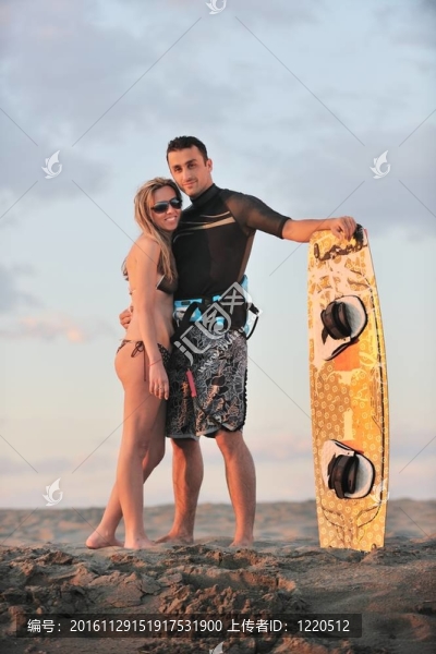 在日落時在海灘上擺姿勢的沖浪夫婦