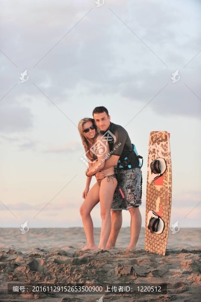 在日落時在海灘上擺姿勢的沖浪夫婦