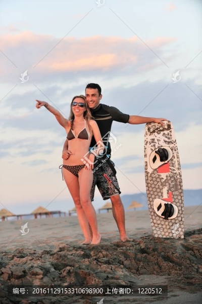 在日落時(shí)在海灘上擺姿勢的沖浪夫婦