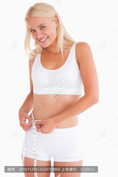 可愛的女人測量她的腰