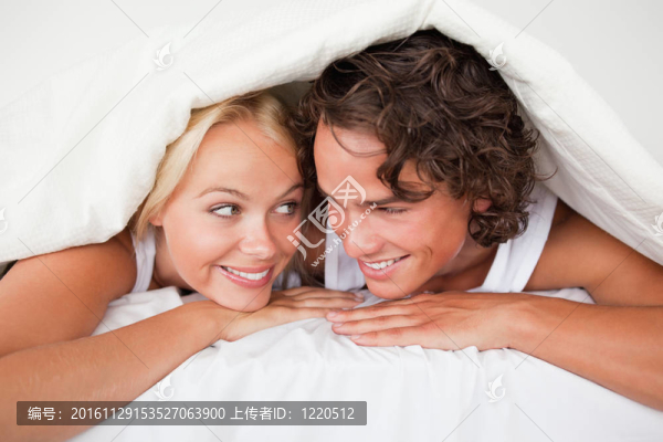 一個會心的微笑在羽絨被下的夫婦