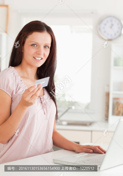 用筆記本顯示信用卡的婦女