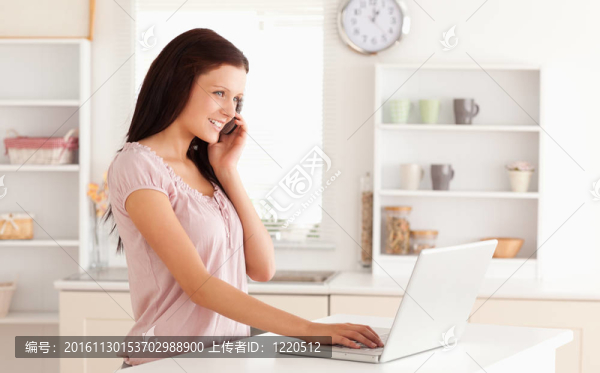 女人打電話和打字的筆記本電腦