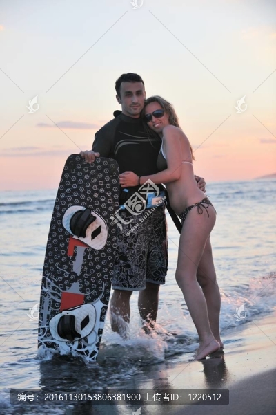 在日落時在海灘上擺姿勢的沖浪夫婦