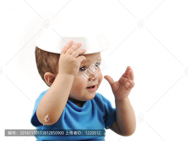 可愛的可愛的一歲的嬰兒在桌子上吃綠色的眼睛；勺子和盤子