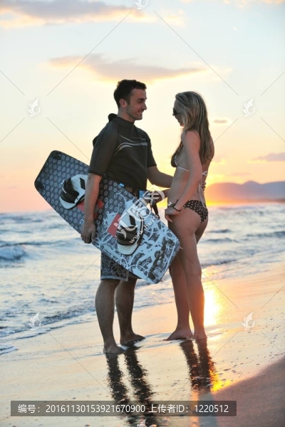 在日落時在海灘上擺姿勢的沖浪夫婦