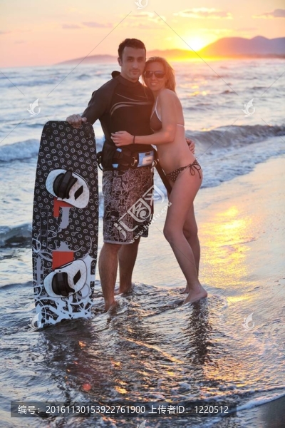 在日落時在海灘上擺姿勢的沖浪夫婦