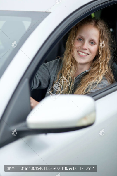 漂亮的年輕女人駕駛她的新車