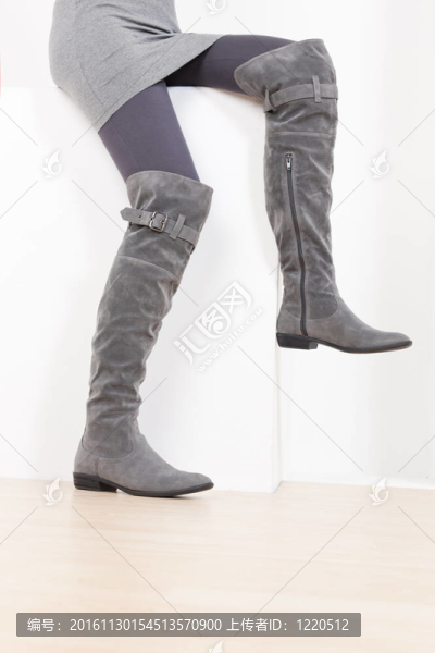 坐著的女人穿著時髦的灰色靴子