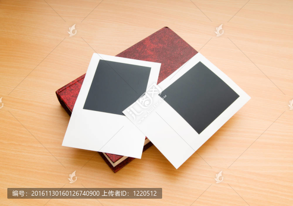 木制桌子上的書和空白照片