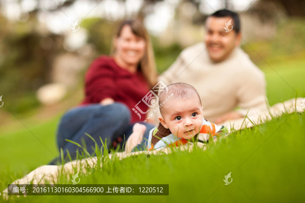快樂(lè)的男孩和混合種族的父母在公園里玩耍