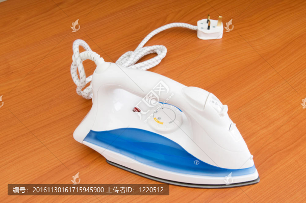 木制背景上的現(xiàn)代電熨斗