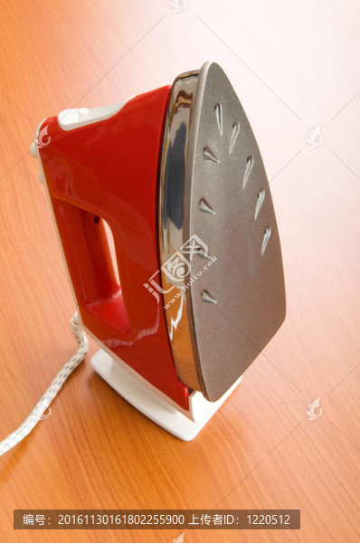 木制背景上的現(xiàn)代電熨斗