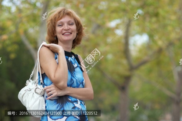 年輕的女人走在秋天的公園