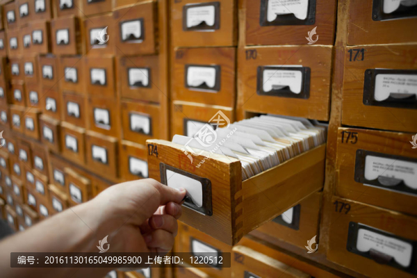 數(shù)據(jù)庫的概念。古董柜。人類手打開圖書館卡或文件目錄框。