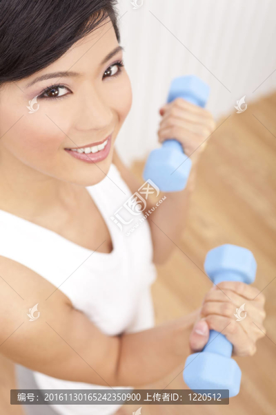 美麗的亞洲年輕中國女子舉重在健身房