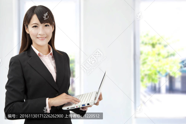 年輕的商人拿著筆記本電腦在辦公室