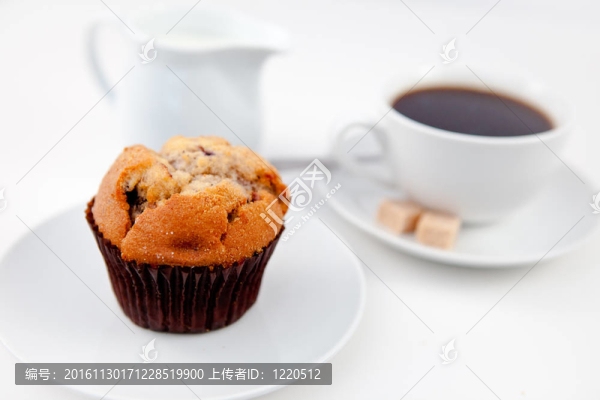 松餅和一杯加糖和奶白色的盤子上的咖啡