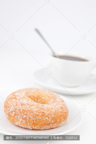 用糖粉和一杯用勺子在咖啡炸圈餅
