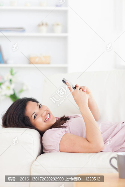 女人在沙發(fā)上休息，手里拿著電話